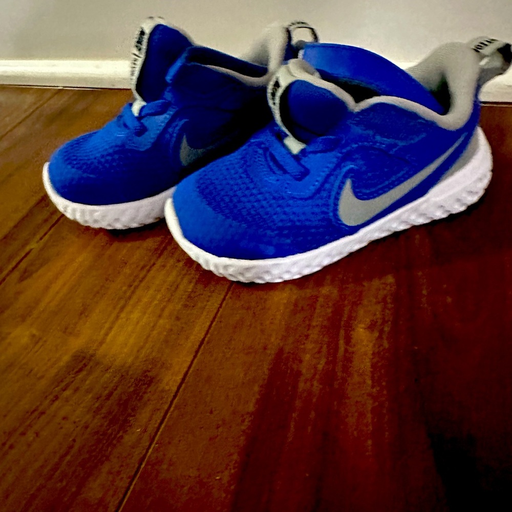 Barley worn bright blue Nike shoes toddler